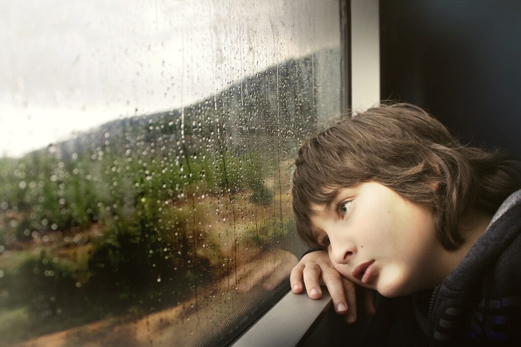 雨を眺める少年